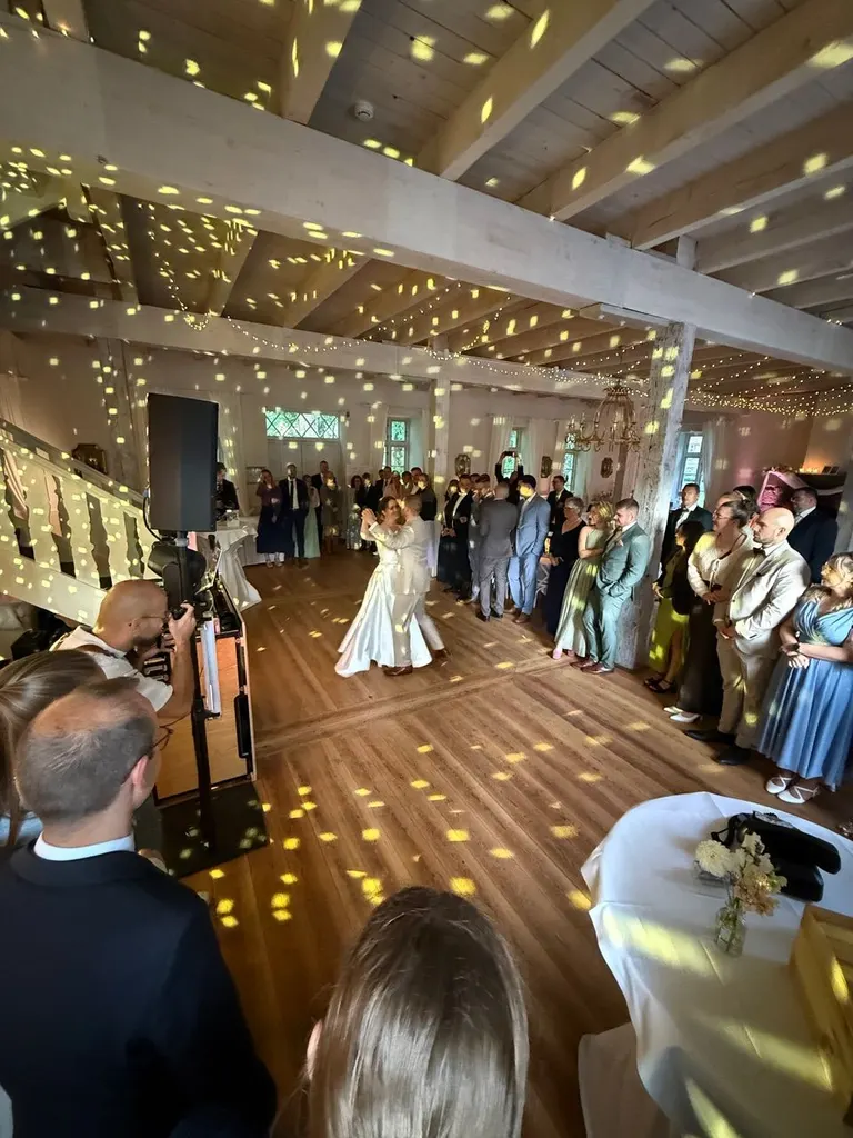 Brautpaar beim Tanz im Saal von Gut Pronstorf, umringt von Gästen