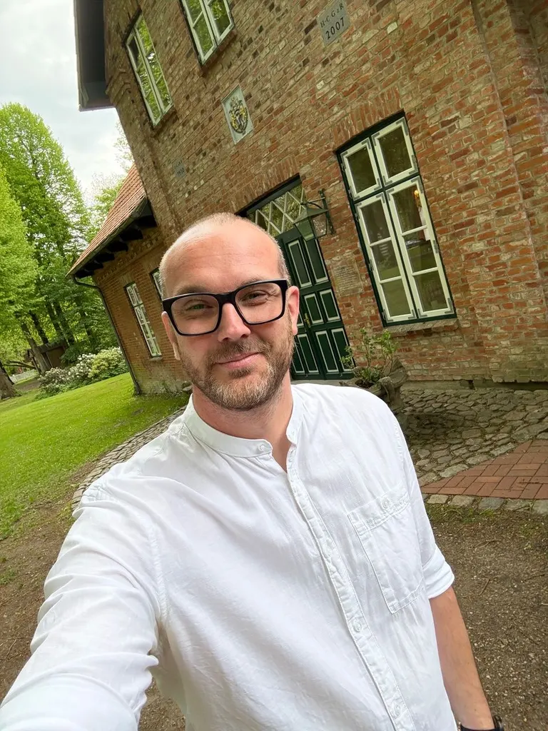 Eike Otto im weißen Hemd vor einem Backsteingebäude auf Gut Pronstorf