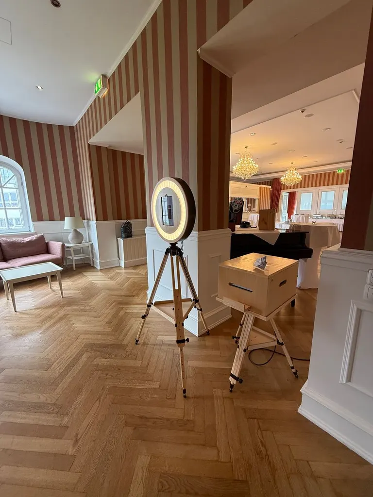 Foyer mit gestreifter Tapete, Fotobox und Sitzecke im Strandhotel Glücksburg