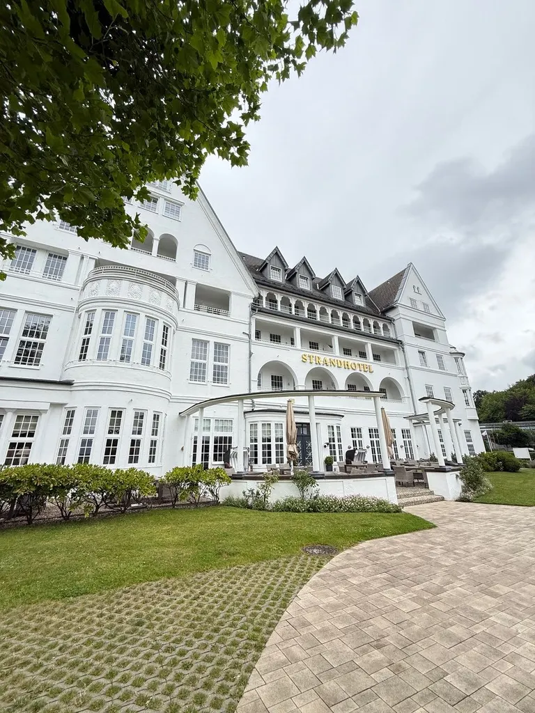 Strandhotel Glücksburg von der Gartenseite mit Terrasse und Rasenfläche